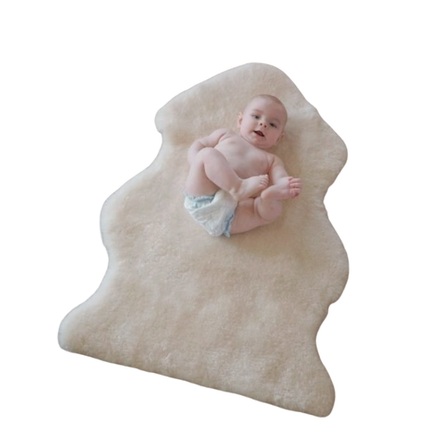Baby lying on a beige Australian sheepskin wool rug against a white background